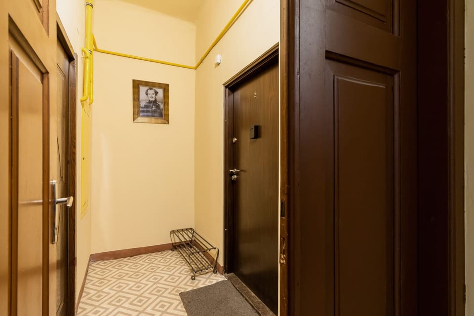 Corridor with wooden doors leading to the apartment.
