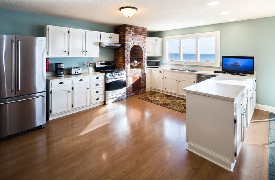 Kitchen workspace - Fully equipped kitchen with large stove and refrigerator.