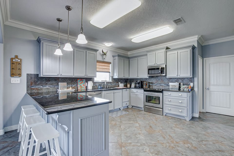 Fully-stocked kitchen with refrigerator, microwave, stove, sink and dishwasher.