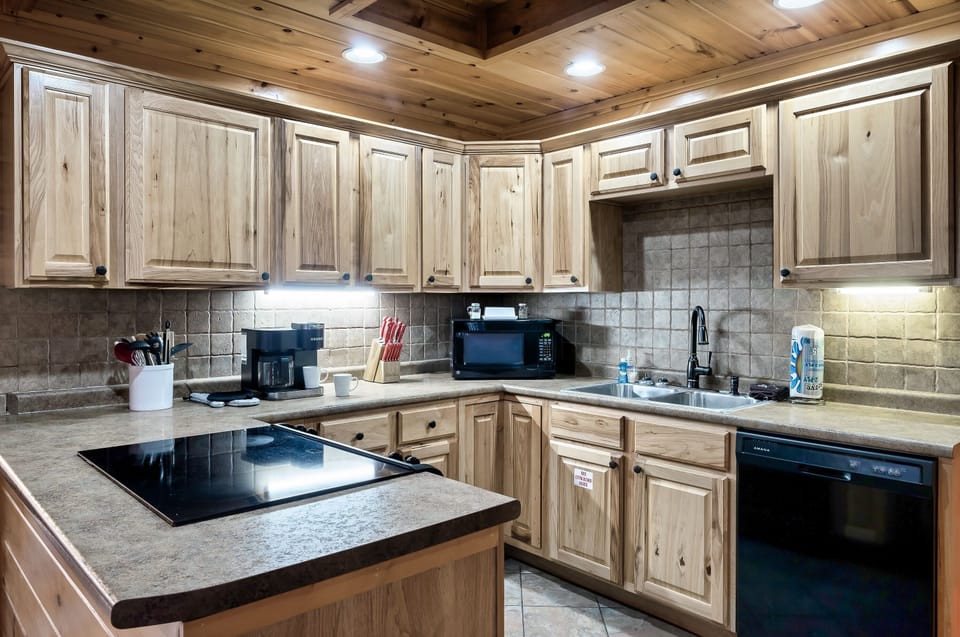 - Spacious cabin kitchen with full appliances and bright wood cabinets   - Perfect setup for cooking meals during relaxing Smoky Mountain stays   - Easy access dining and living area creating a smooth cabin experience