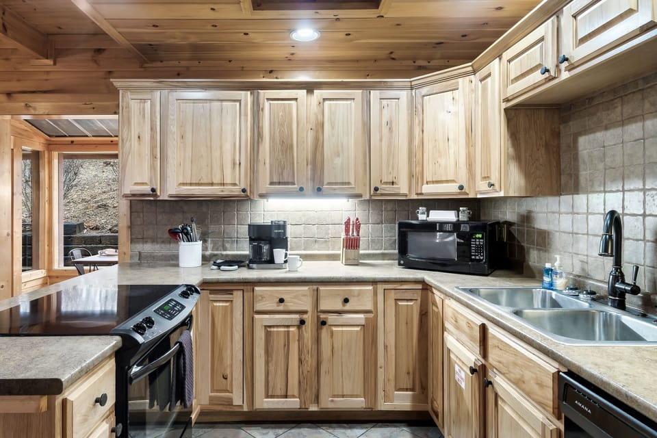 - Full cabin kitchen with stove microwave and coffee setup for guests   - Ample counter space makes meal prep easy during Smoky Mountain stays   - Cozy layout connecting kitchen dining and living areas seamlessly