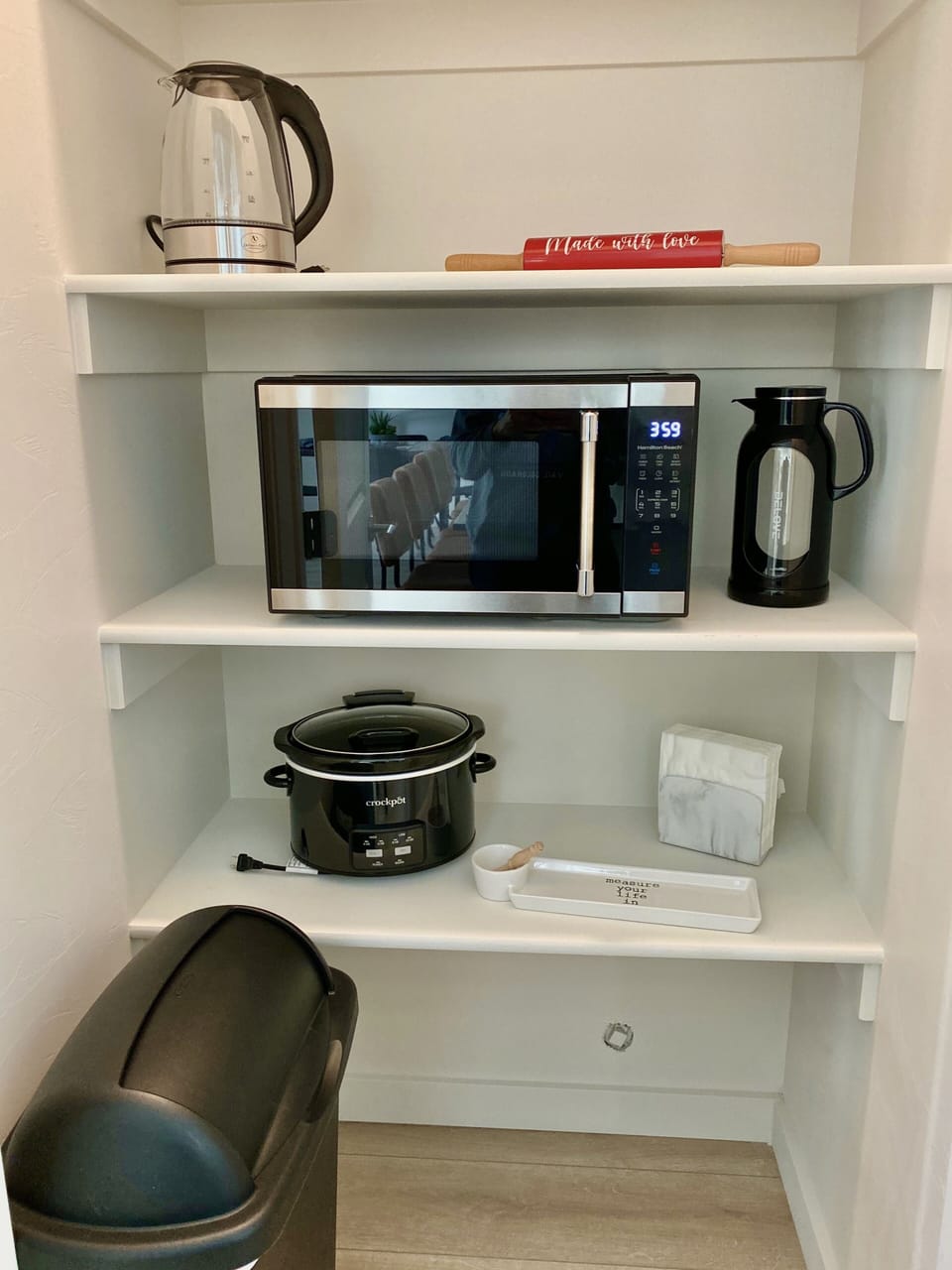 The microwave, crock pot, second trash can, and more are located in the pantry