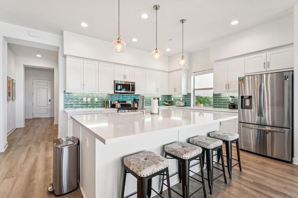 Modern kitchen w/ large island seating, pendant lighting & stainless steel appliances
