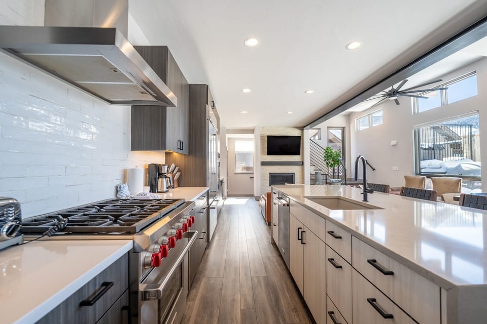 Luxury full-sized kitchen with high-end stainless steel appliances, granite countertops, tons of cabinet space, and dedicated wine fridge.