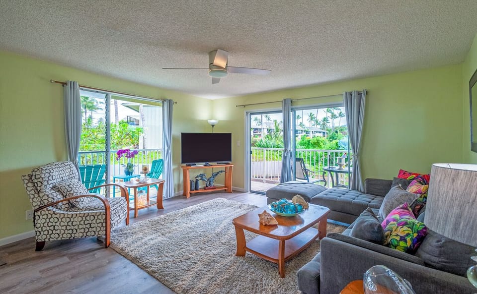 Alii Kai 1201 Kauai Condo - The living room is bright and cheerful thanks to the wrap-around lanai windows and charming natural wood accents.