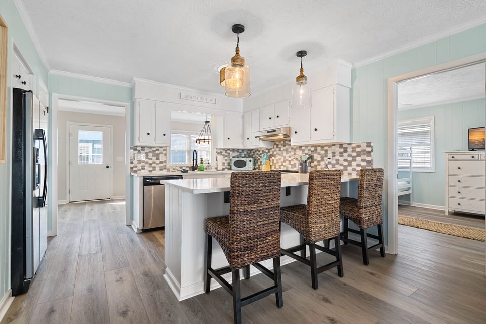 Updated kitchen with beachy backsplash bar seating for 3 and updated lighting.