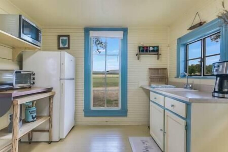 Kitchen with full size refrigerator, convection oven, microwave, and coffee pot