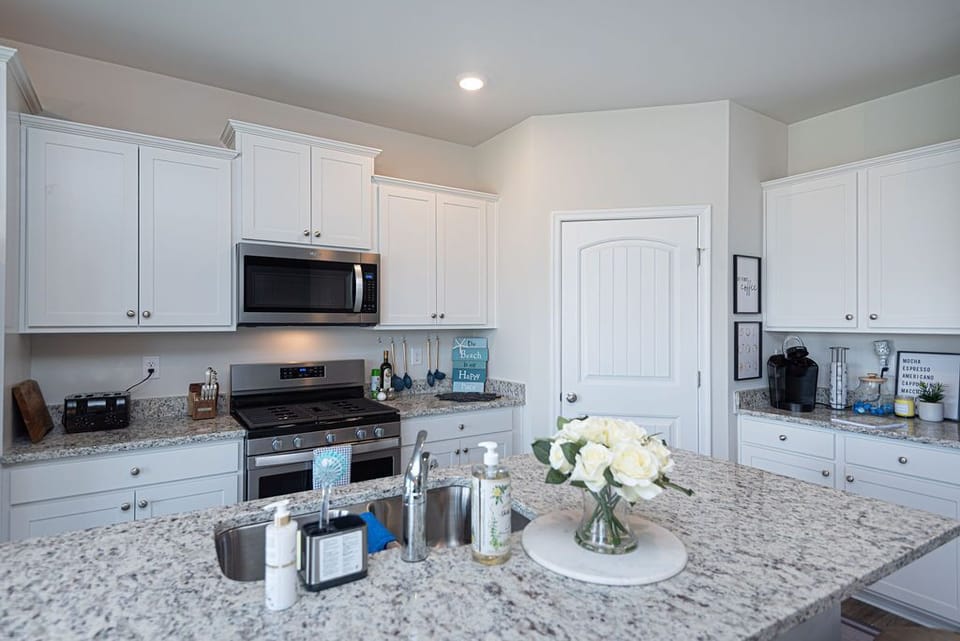 Kitchen has dishwasher, microwave, stove, refrigerator, pantry, storage, toaster