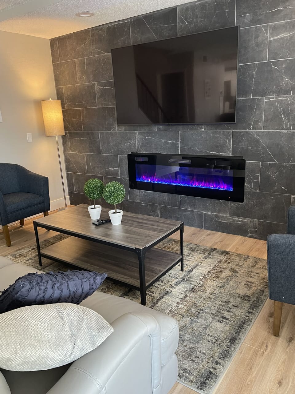 65" smart TV with modern fireplace in family room.