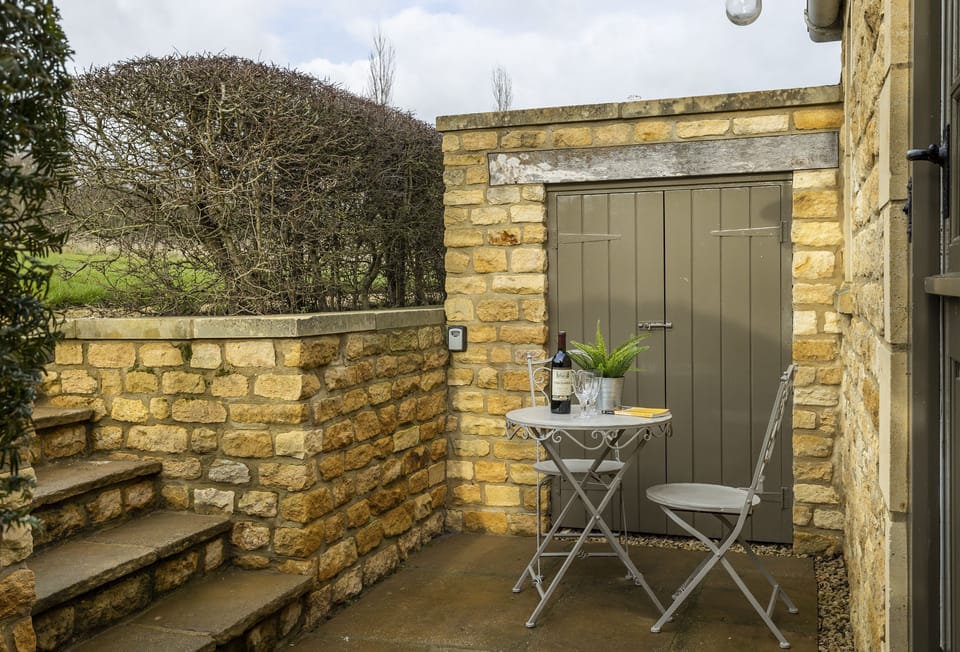 Claytons Hideaway, Lower Oddington: Steps down to the entrance with patio area and garden furniture