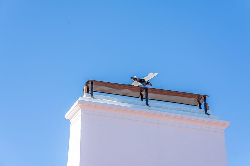 Rooftop with wooden beam and weathervane against clear sky — Villa Casanova, holiday villa in Santiago do Cacém