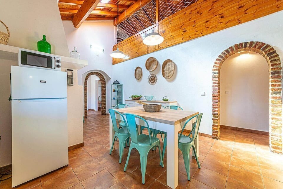 Open-plan kitchen and dining room with turquoise chairs — Villa Casanova, holiday villa in Santiago do Cacém
