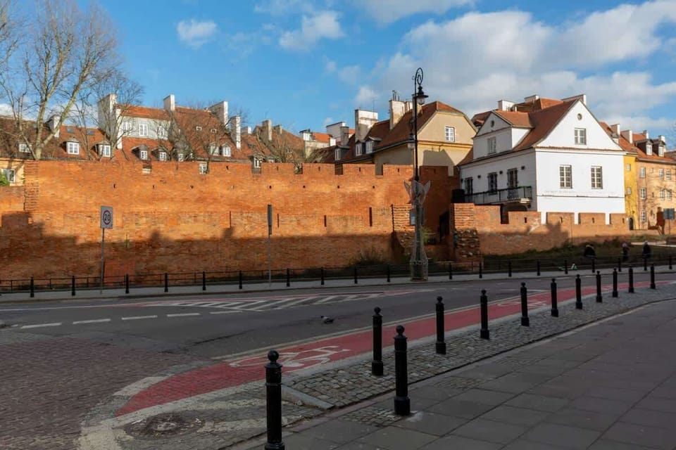 A picturesque street with historic walls, cobblestone paths, and charming surroundings.
