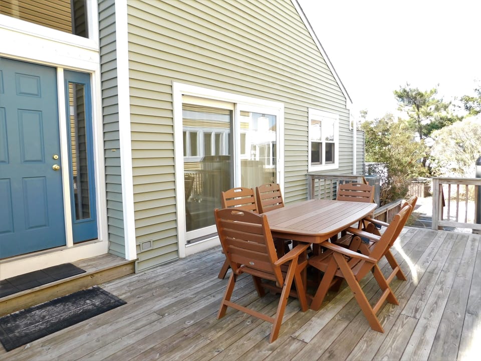 105 Cedarwood Street Outdoor Deck with Dining Table and Chairs - A view of the property's spacious wooden deck featuring a full outdoor dining set and direct access to the home.