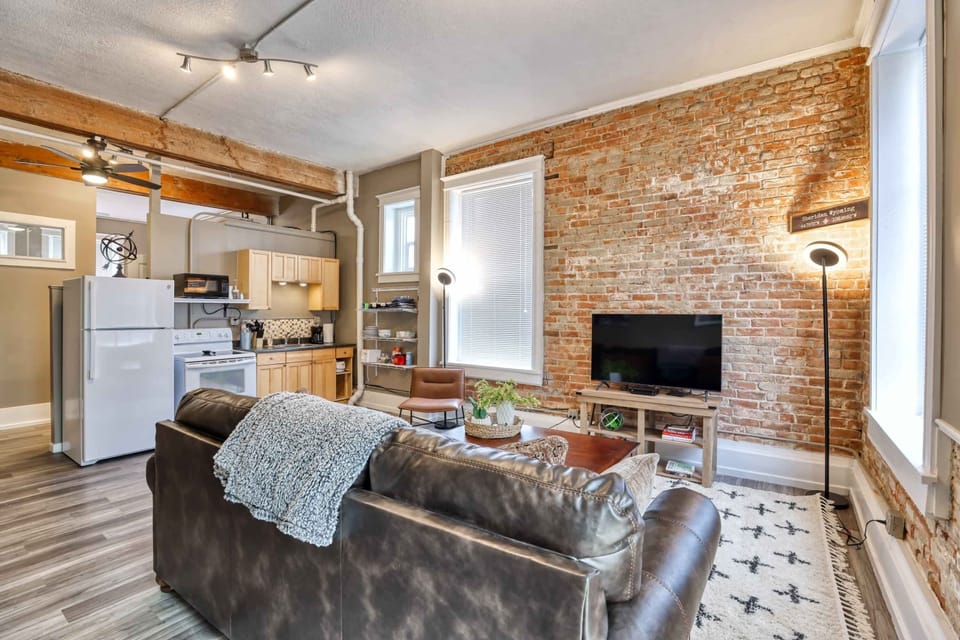 Sleeper sofa in a modern industrial down town suite for the extra guests, with a smart TV!