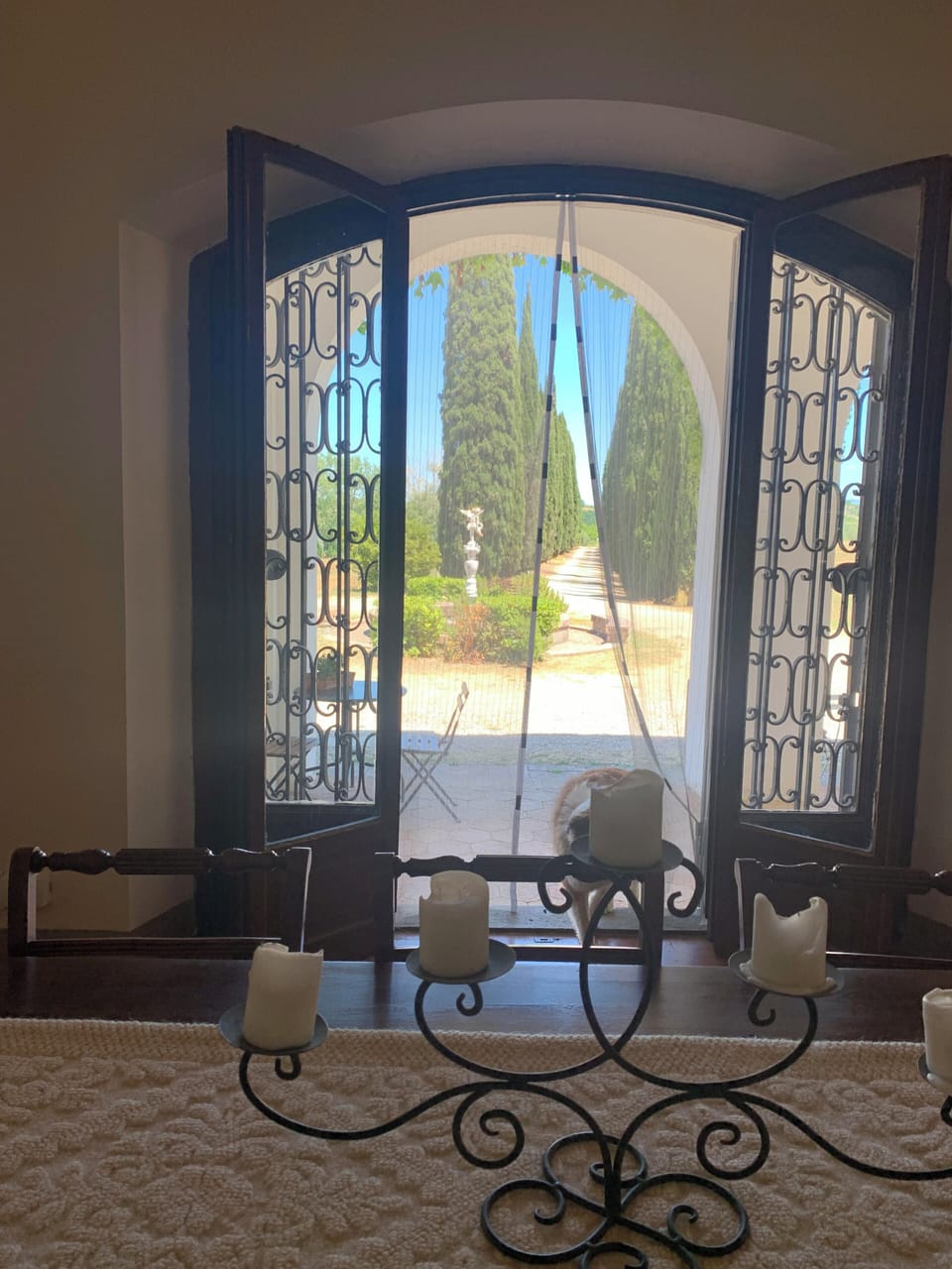 Step outside to a stunning Tuscan garden path framed by wrought iron doors 
