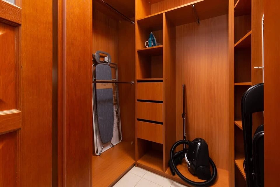 A storage area with built-in wooden wardrobes, providing ample space for clothes and accessories.