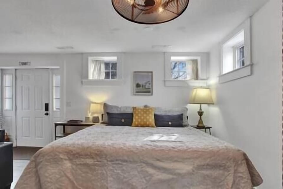 King bed with soft linens and extra pillows.