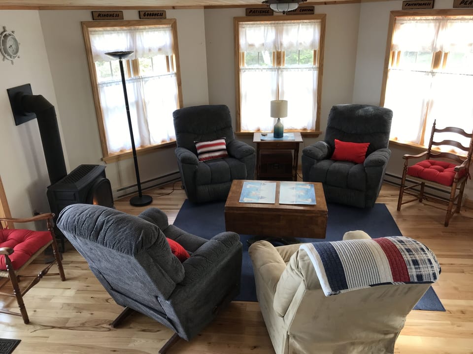 Living room has comfortable chairs for cozy conversation and entertainment