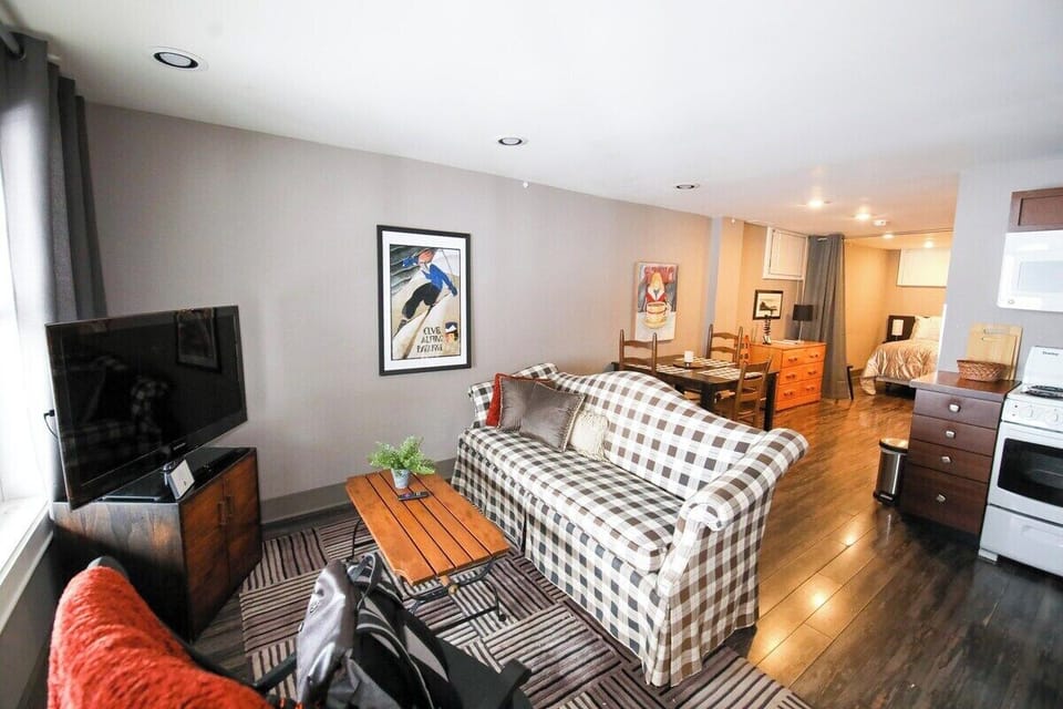 Open floor plan of apartment, with Adirondack touches and furnishings, connected to kitchen