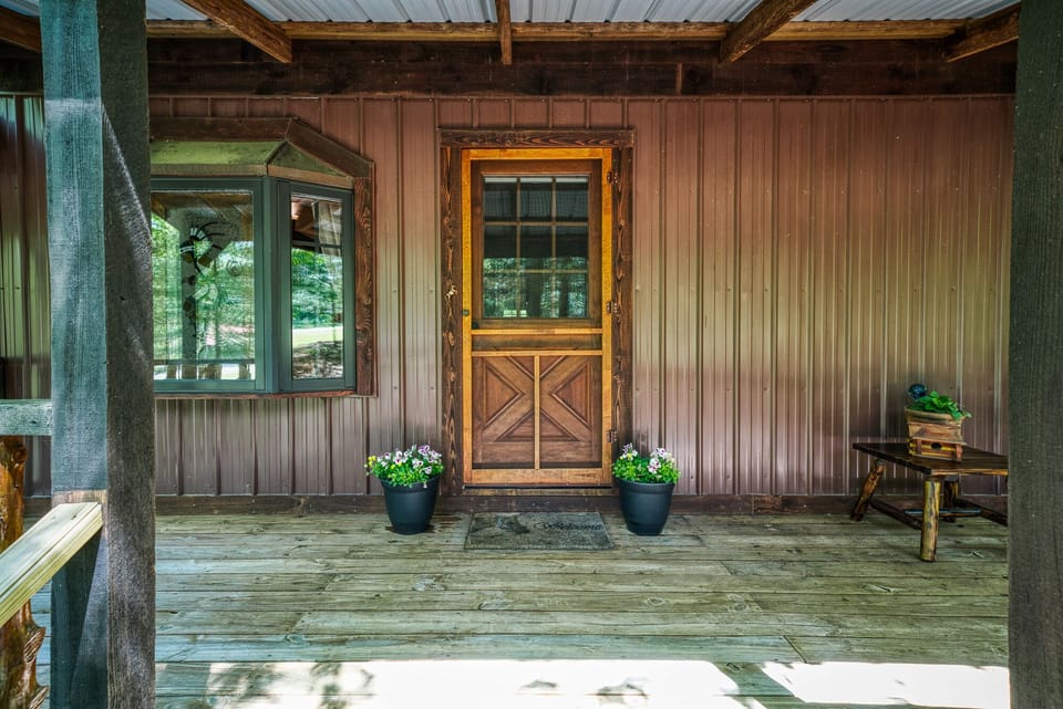 Front entrance of Cabin with vista views of horse trail paths and wooded areas.