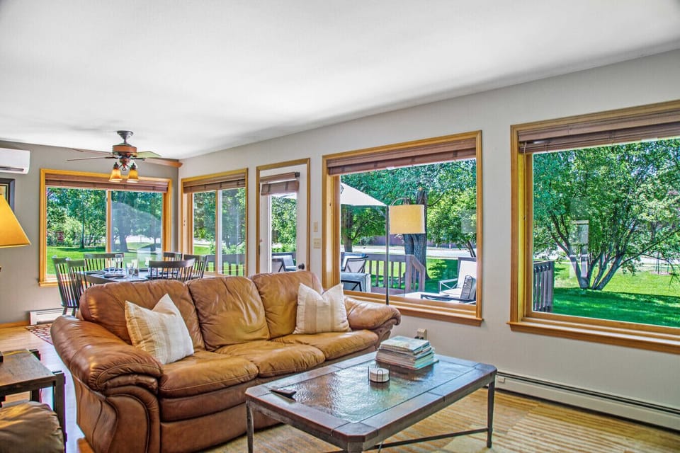 Living room with huge windows showcasing park-like backyard