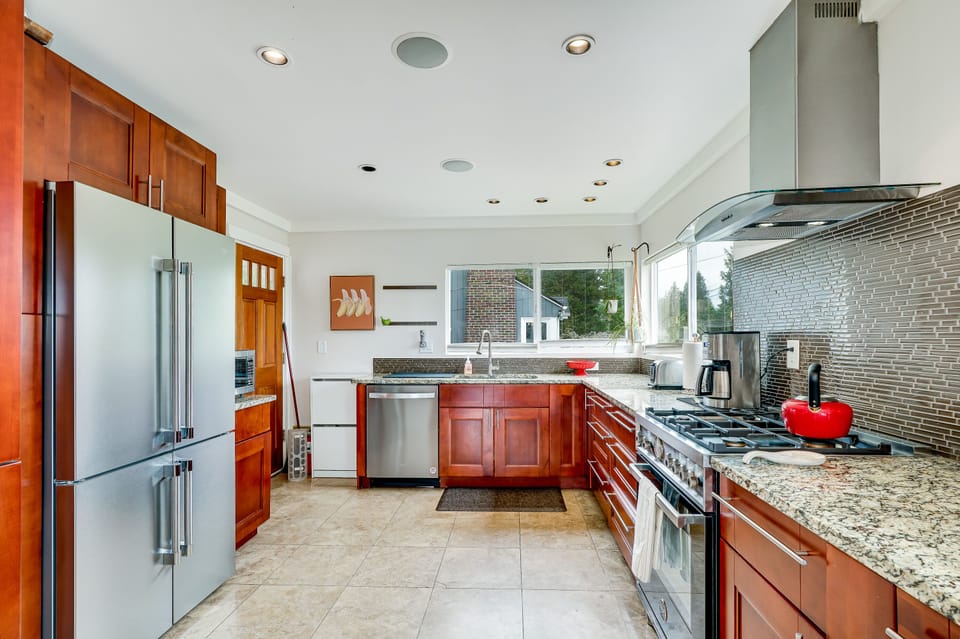 Chef's kitchen with Bertazzoni gas range, granite countertops, new appliances.