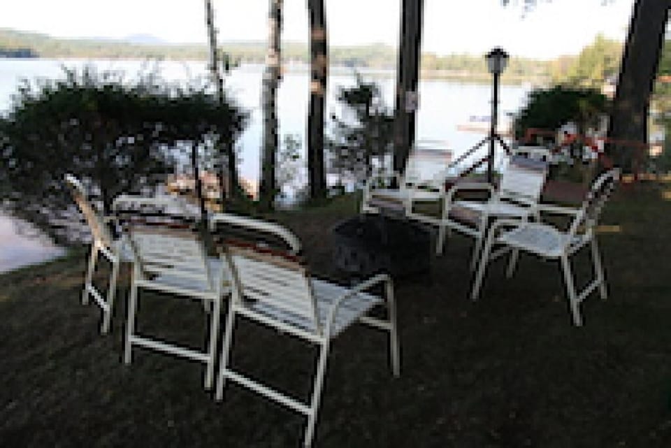 Lake House Exterior lawn chairs around fire pit overlooking lake