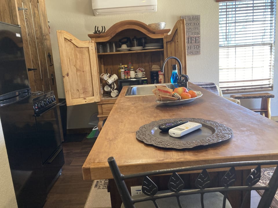 Coffee/tea bar with microwave and dishes and glassware 