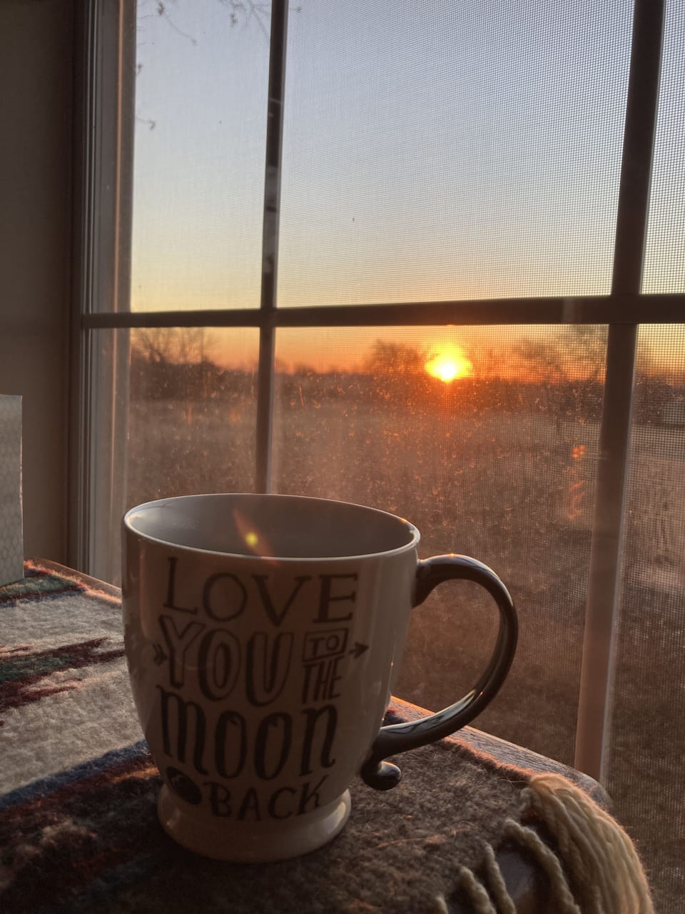 Coffee with a peaceful sunrise overlooking a natural field with birds singing 