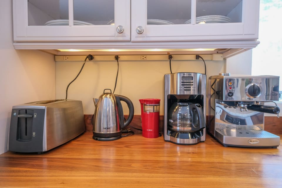 Toaster, tea kettle, coffee grinder, drip coffee pot, and espresso maker with milk frother.  