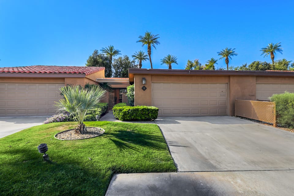 Exterior front w/ full two car garage & gated entrance to the front patio..