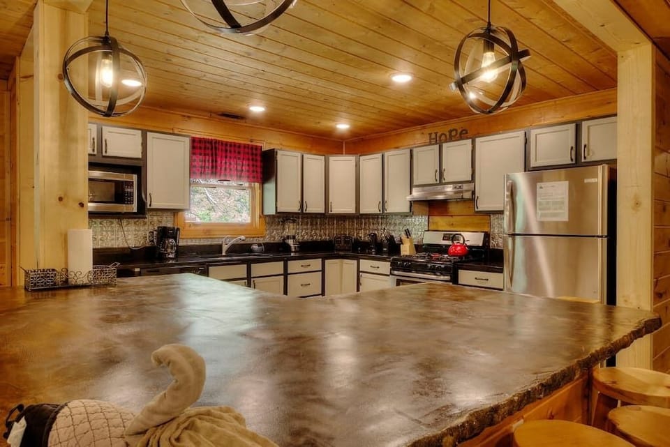 Modern, open-style kitchen with counter seating. All kitchen essentials are provided, including 12 cup coffee pot, crockpots, rice cooker, blender, children plates/cups/silverware, and more. 