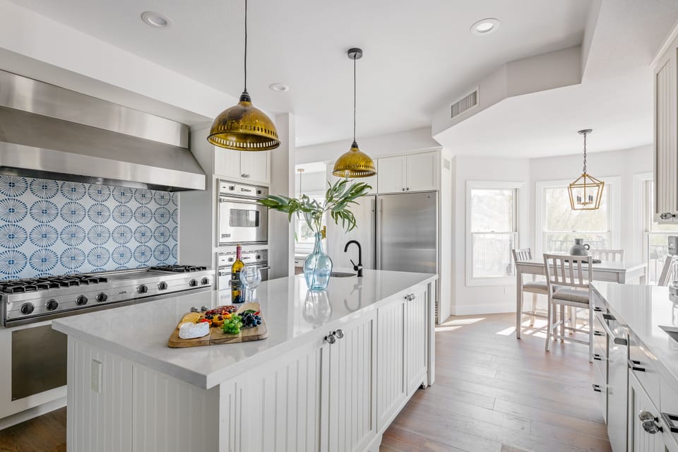 Bright fully equipped kitchen with stainless steel appliances, dual ovens, dual sinks, XL fridge, large island and breakfast table with incredible views of Camelback.