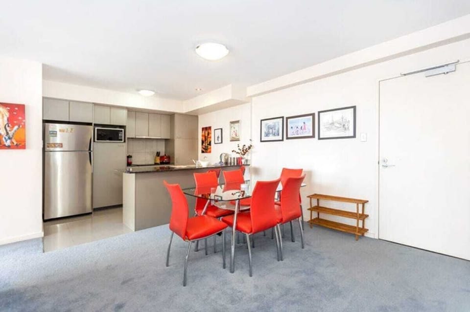 Enjoy the convenience of the combined dining and kitchen area, featuring a dining table that comfortably seats six. The well-equipped kitchen includes a kitchen island, refrigerator, microwave, stove, and other appliances for your cooking needs. 