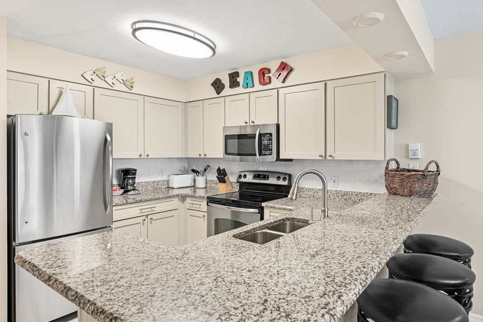 Your fully equipped kitchen awaits with granite counters, stainless appliances, and breakfast bar seating for casual meals.
