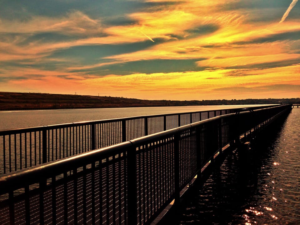 Unwind at sunset with shimmering water and golden skies.