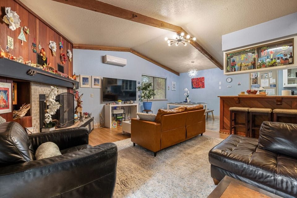 Open living space featuring a private bar, cozy fireplace, and plush seating