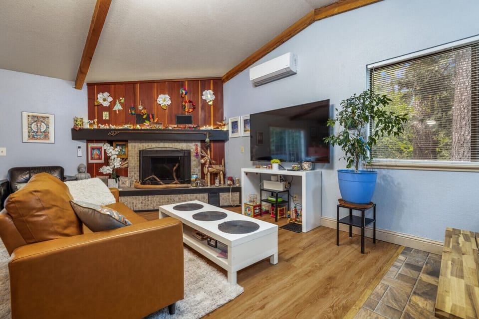 Deep leather seating, a traditional fireplace, and view of the woods: the ultimate cozy retreat.