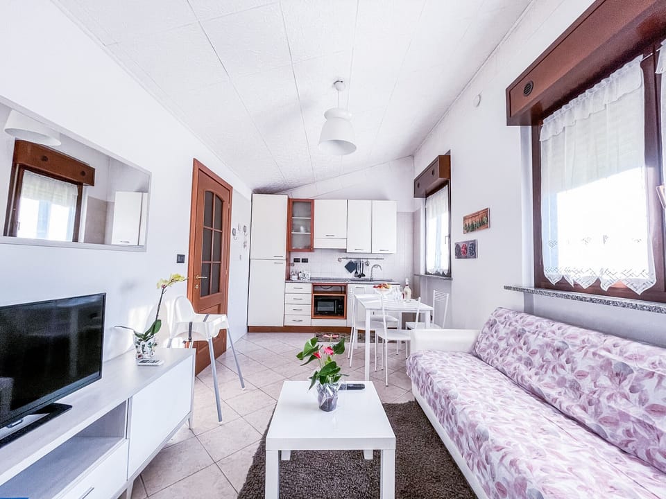 Living room with induction kitchenette, microwave oven and complete crockery. Comfortable sofa bed with dresser, 32" flat-screen TV and Wi-Fi connection for a comfortable and practical stay.