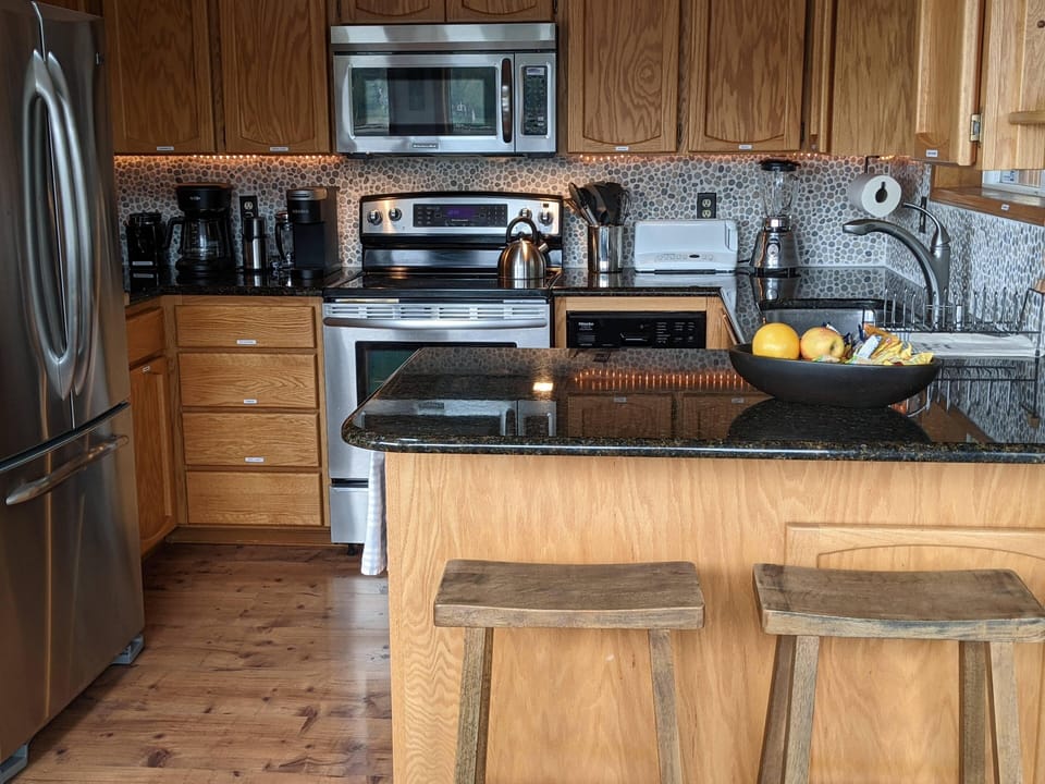 The kitchen has a small dishwasher, a microwave, a blender, and a toaster. 