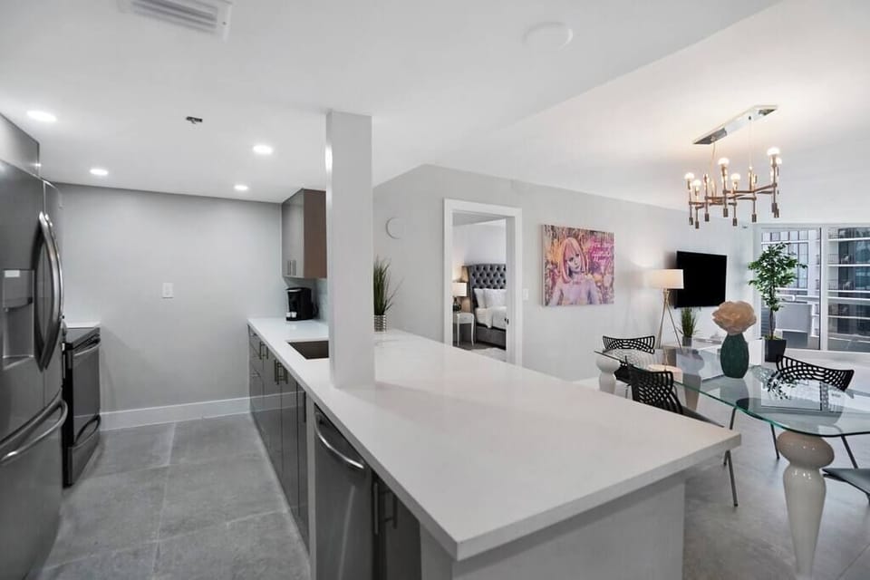 Fully equipped kitchen, dining area, view into master bedroom suite