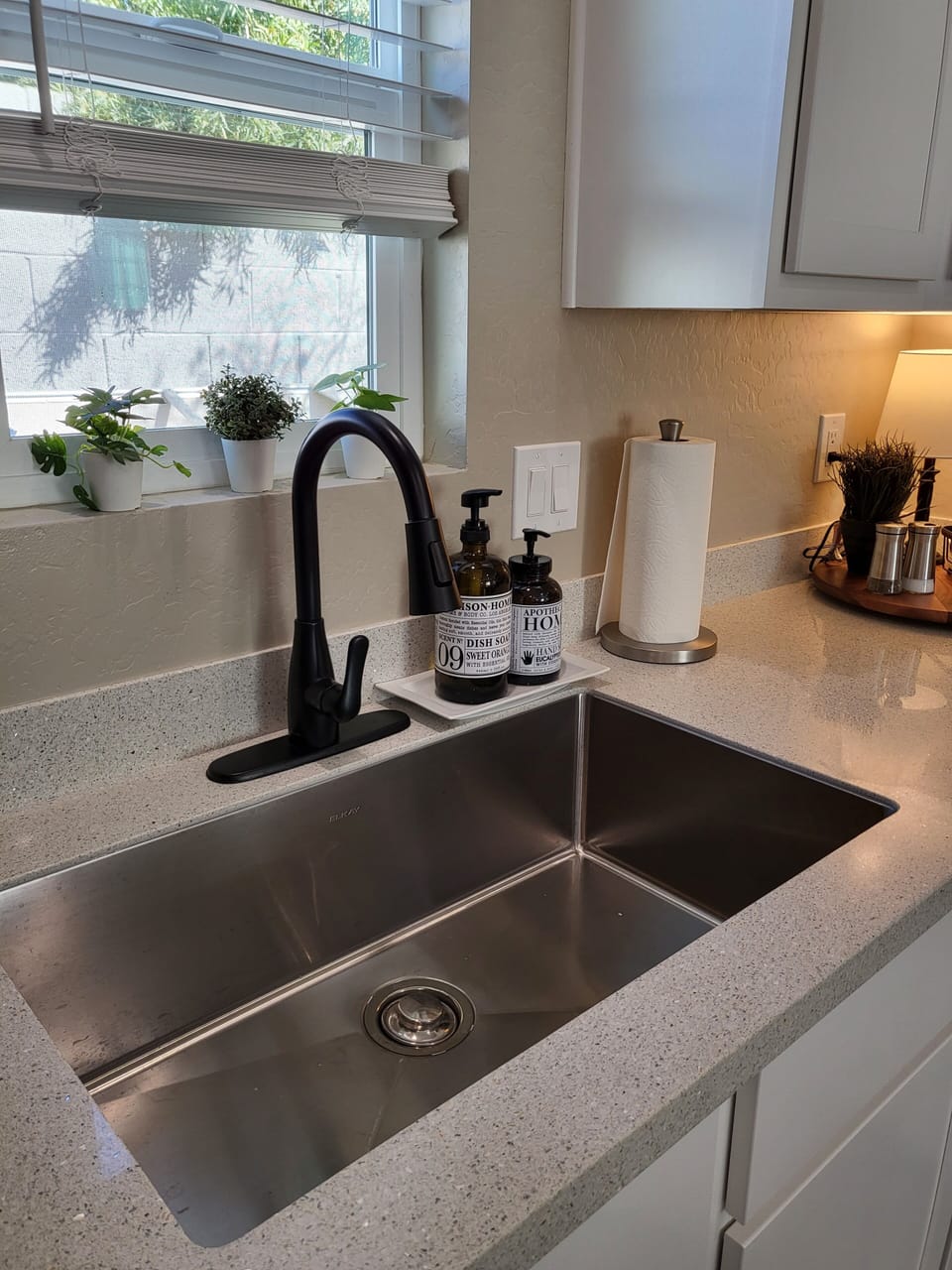 Kitchen sink with pull down faucet, soap, outside view from the window