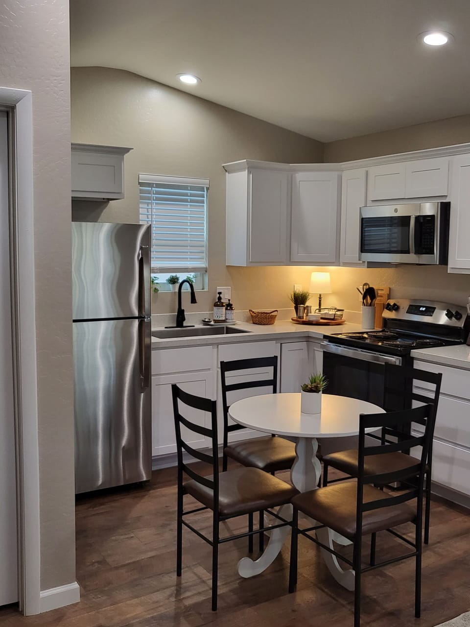 Fully equipped kitchen with table, fridge, stove, microwave and coffee maker 