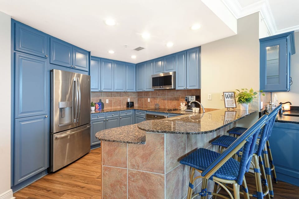 Your spacious kitchen features gorgeous blue cabinetry, granite countertops, and modern appliances perfect for cooking memorable meals together.