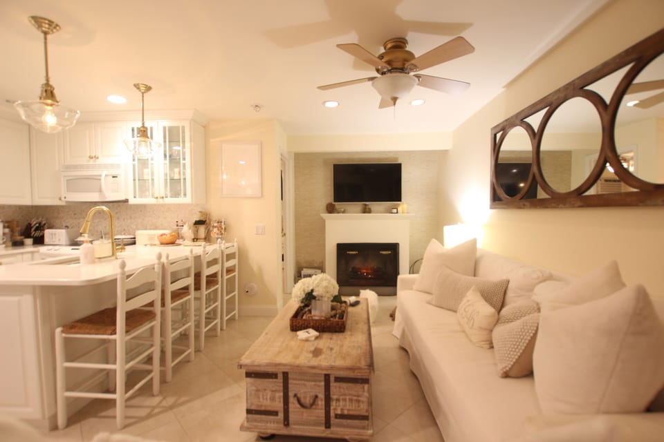 Open floor plan with full kitchen, fireplace, flat screen TV, two large sofas 