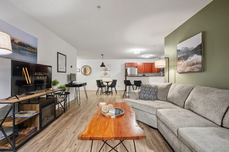 Spacious living area with a Smart TV, electric fireplace, pull-out sleeper sofa and walkout access to the ground-floor patio space.