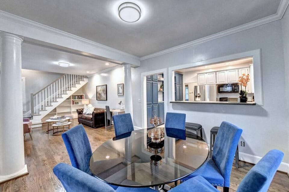 Elegant dining area with a large glass table, comfortable leather chairs, and a beautiful flower centerpiece, creating the perfect setting for memorable meals and gatherings.