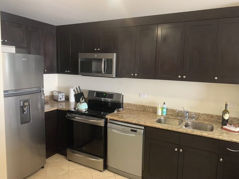 Beautiful kitchen with granite counters, fridge, oven, dishwasher, microwave. 