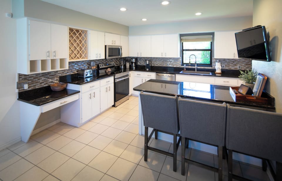 Fully equipped kitchen with breakfast bar and dining table.